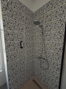 a shower in a bathroom with a tiled wall at Lalzi Vacation Apartment in Lalzit Bay