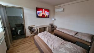 a bedroom with two beds and a desk and a mirror at Vila Vivien in Zlín