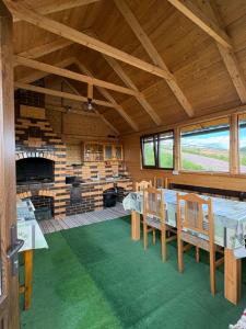 a room with a table and chairs and a fireplace at Cabana Colț De Munte in Ocoale