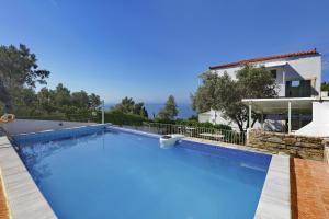 a large swimming pool in front of a house at Pelagos in Stafylos