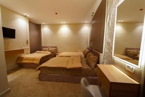 a room with three beds and a mirror at Sydney DownTown-Cairo in Cairo
