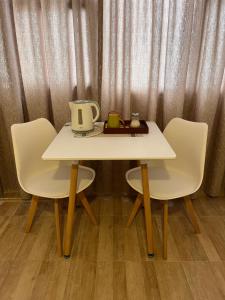a table with two chairs and a tea pot on it at Astoria Patagonia habitaciones privadas in San Carlos de Bariloche