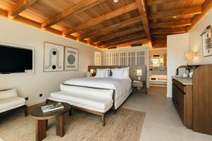 a bedroom with a large white bed and a couch at Epi Baie de Pampelonne in Saint-Tropez +77 photos