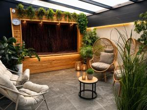 a patio with two chairs and a table and plants at WILLA LAZUR in Łeba