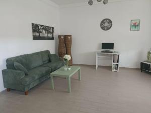 a living room with a green couch and a table at VERDEDERA Casa Vacanze in Portocannone