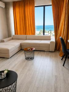 a living room with a white couch and an orange curtain at Italy Luxury Apartment front of the sea in Mamaia Sat/Năvodari