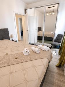 a bedroom with a bed with two towels and a mirror at Italy Luxury Apartment front of the sea in Mamaia Sat/Năvodari +95 photos
