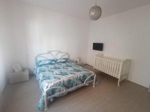 a bedroom with a bed and a tv on the wall at VERDEDERA Casa Vacanze in Portocannone