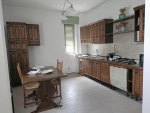 a kitchen with wooden cabinets and a wooden table in it at VERDEDERA Casa Vacanze in Portocannone
