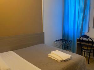 a bedroom with a bed with two towels on it at Hotel New Primula in Rimini