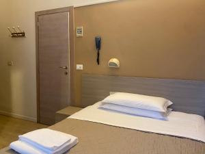 a bedroom with a bed with a phone on the wall at Hotel New Primula in Rimini +10 photos
