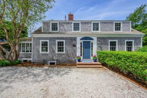 a white brick house with a blue door at Sand Simeon - Relax, Unwind, Repeat in Chatham