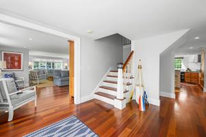 a living room with white walls and a staircase at Sand Simeon - Relax, Unwind, Repeat in Chatham +76 photos