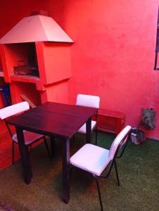 a table with white chairs and a red wall at Casa privada en Maimara in Maimará +13 photos