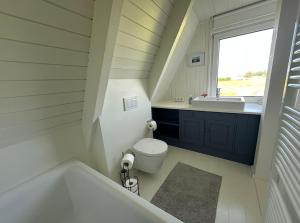 ein Badezimmer mit Badewanne, Toilette und Waschbecken in der Unterkunft Schleirauschen in Klein Brodersby