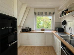 eine Küche mit Spüle und Fenster in der Unterkunft Schleirauschen in Klein Brodersby