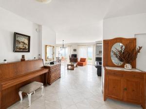 a large living room with a piano and a living room at ENDLESS BLUE WAVE in Paleo Tsifliki