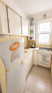 a kitchen with a white refrigerator and a window at Alojamiento céntrico con Wi-Fi in Mar del Plata