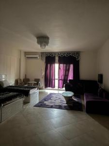 a large living room with a couch and a window at Marina Valley مارينا فالي in El Alamein