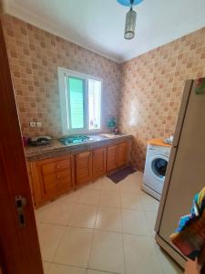 a kitchen with a sink and a washing machine at Martil, Avenue Oum Kalthoum in Martil