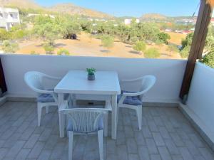 a white table and chairs on a balcony with a view at Marias Apartment in Kolymbia