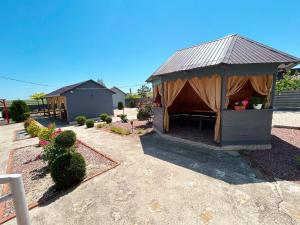 a gazebo with a table and chairs in a yard at Cazare Nicoleta in Vadu