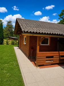 a small wooden cabin with a chair in a yard at Bungalow Perun in Blejska Dobrava