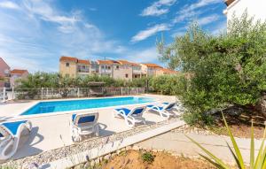 a swimming pool with lounge chairs next to a building at Olive Dreams in Biograd na Moru