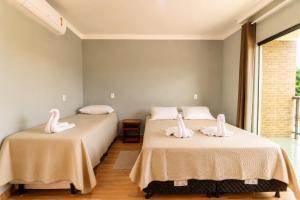 two beds with white swans on them in a room at Pousada Voo das Garças in Bonito
