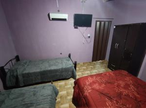 a room with two beds and a tv in it at Virgen del valle in Fiambalá
