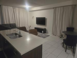 a kitchen and living room with a sink and a tv at Short stay and exploring the city in Markham