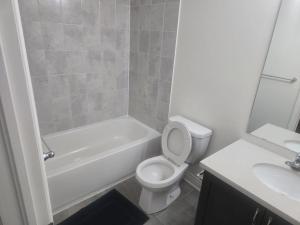 a bathroom with a toilet and a tub and a sink at Short stay and exploring the city in Markham +2 photos