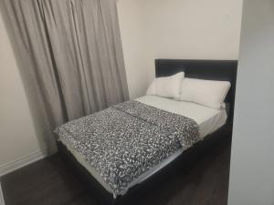 a bed with a black and white comforter and pillows at Short stay and exploring the city in Markham