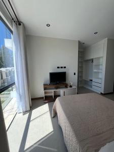 a bedroom with a bed and a large window at Monoambiente Amplio in Tarija +7 photos