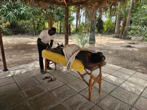 a man is laying on a bed with a person at Tendinkoto Lodge in Sanyang +46 photos