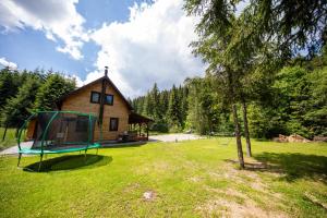 a cabin in the woods with a playground in the yard at Czirják Kulcsosház in Bucsin