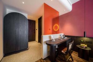 a kitchen with a black table and red walls at M Hotel in Hangzhou