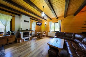 a living room with a leather couch and a table at Czirják Kulcsosház in Bucsin