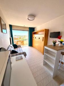 a living room with a couch and a table at Studio 100m de la mer et port in Valras-Plage