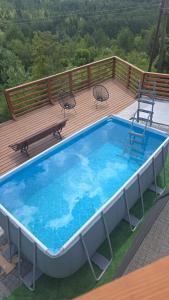 a large swimming pool on a deck with two chairs at Dom na Cieńkowie in Wisła
