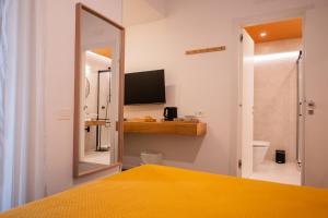a bedroom with a mirror and a yellow bed at Garibaldi Suite B&B in Salerno +169 photos