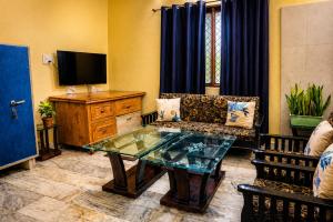 a living room with a couch and a glass table at Ranibagh Riverview Retreat in Kāthgodām
