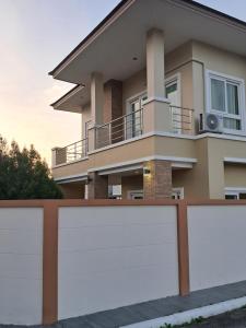 a house with a white fence in front of it at Minie House Hatyai in Hat Yai