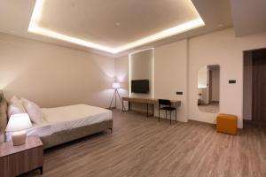 a bedroom with a bed and a desk and a television at Mansions by HomeSlice in Bangalore