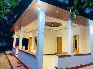 a house with a porch with a roof at Lotus Green Hotel And Restaurant in Arugam Bay