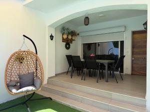 a dining room and living room with a hanging chair at Casa en empuriabrava in Empuriabrava