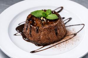 a piece of chocolate cake with a mint on a plate at Hotel Degli Angeli in Pontinvrea