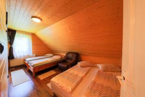 a room with two beds and a chair in it at Czirják Kulcsosház in Bucsin