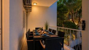 a dining table on the balcony of a house at Zalazak in Bobovišća
