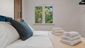 a bedroom with a white bed with towels on it at Zalazak in Bobovišća +24 photos